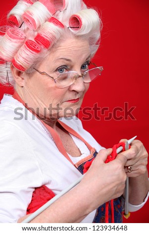Old lady wearing hair rollers and knitting