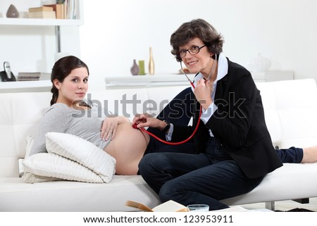 General practitioner and pregnant woman at home