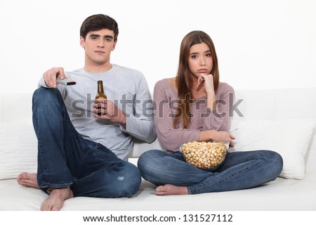 Bored couple watching TV