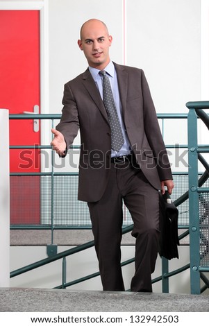 Businessman with briefcase holding out hand
