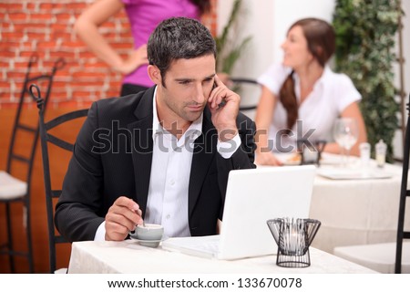 Man in restaurant with computer and phone