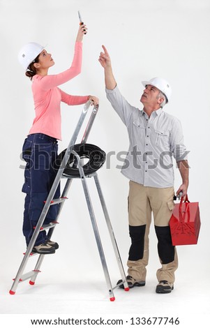 Two electricians working on ceiling lighting