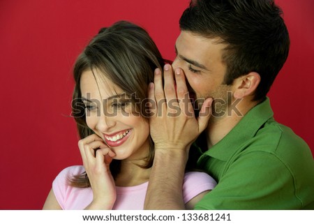 Man telling secret to woman