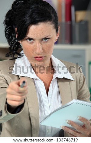 Stern woman pointing pen