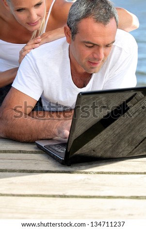 Man lying with a woman behind computer