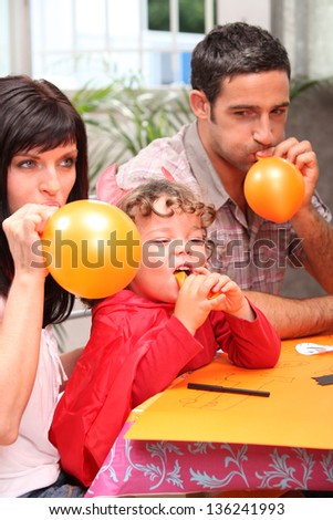 Family blowing balloons for a party