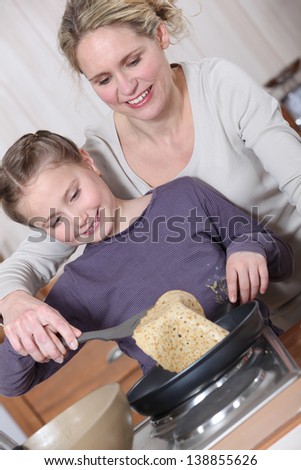Mother and daughter cooking pancakes