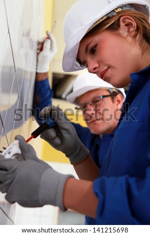 Young woman installing an electrical outlet