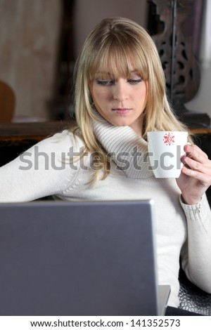 Woman in turtle-neck sweater holding mug of coffee