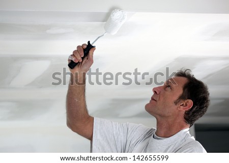 Man painting his ceiling white