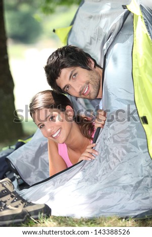Young couple sticking their heads out of a tent door