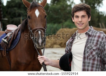 Man stood by brown horse