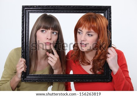 girls behind a wooden frame