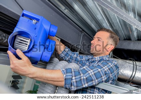 Electrician fitting a ventilation system