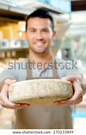 Man holding a wheel of cheese