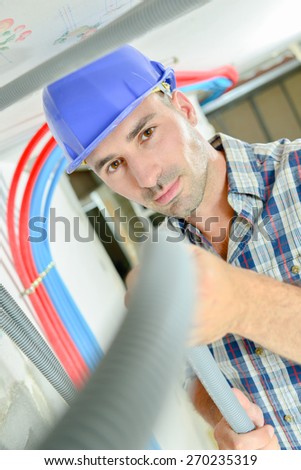 Electrician working through an open ceiling hatch