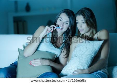 Two female friends watching a scary movie