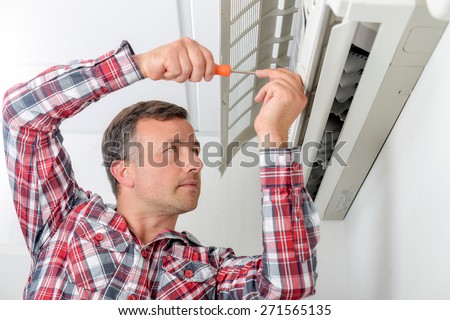 Man repairing his air conditioning system