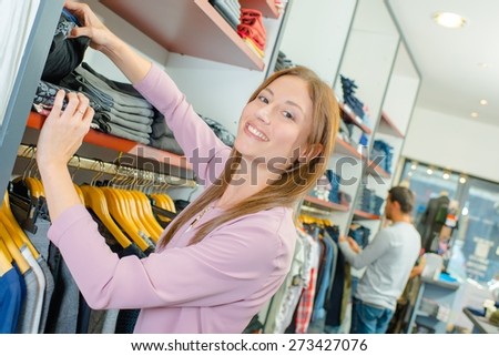 Shop assistant stacking shelves