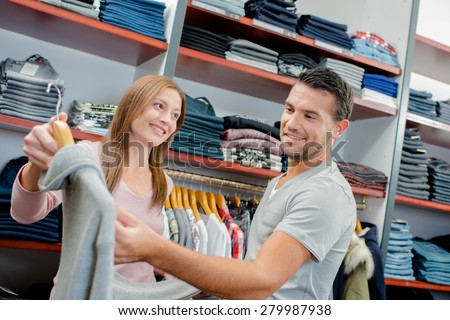 Couple shopping, man looking at price tag