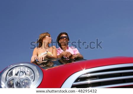 Couple in red convertible car