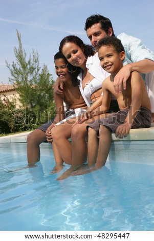 Family sitting by a swimming-pool