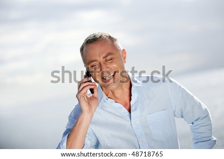 Man talking on mobile phone by the sea
