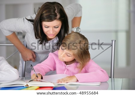 Mother helping little girl to do homework