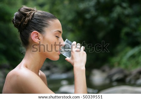 Portrait of young woman drinking water from a glass