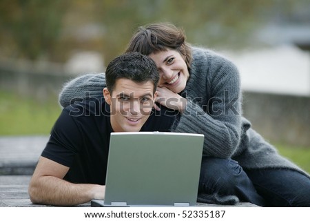 Smiling man and woman in front of a laptop computer