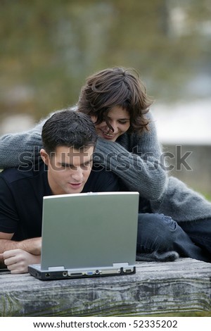 Smiling woman and man in front of a laptop computer