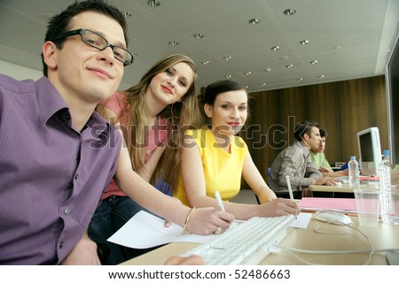 Smiling man and women in front of a laptop computer
