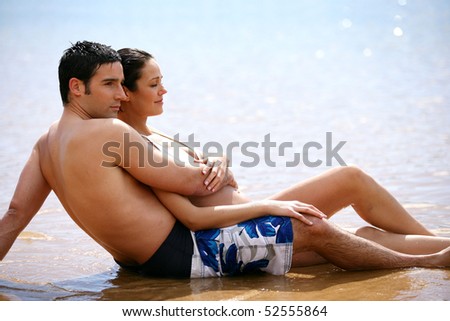 Happy couple sitting in the sand