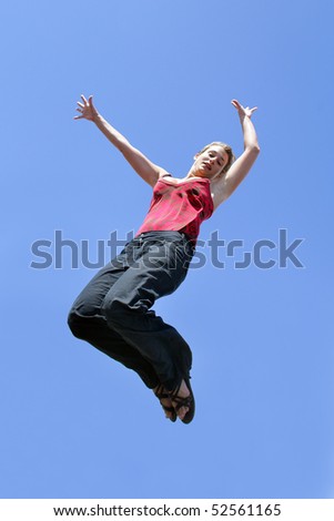 Happy woman jumping in the air with arms up