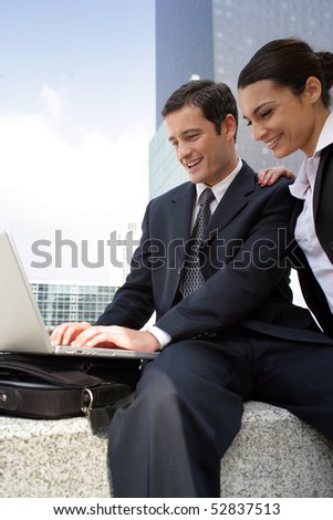 Portrait of  smiling man and woman in front of a laptop computer