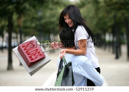 Happy woman embracing a man with sales bags