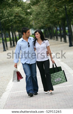 A man and a woman walking with sales bags