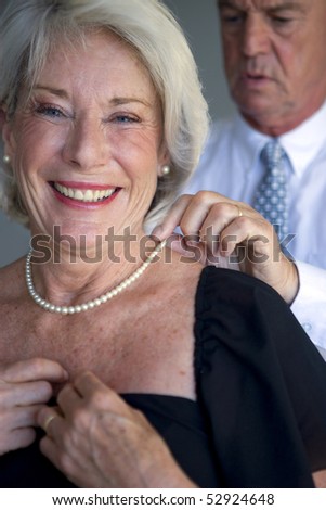 Man closing an old woman necklace