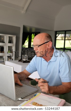 Portrait of an old man in front a laptop computer