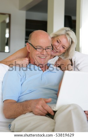 Portrait of a happy senior couple in front of a laptop computer