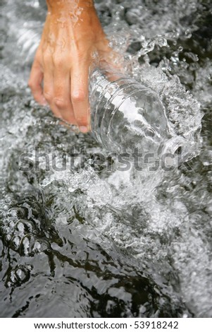 Woman filling a bottle of water in a river