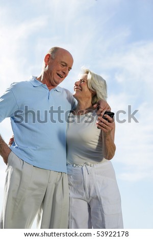 Portrait of a couple of smiling seniors with a phone