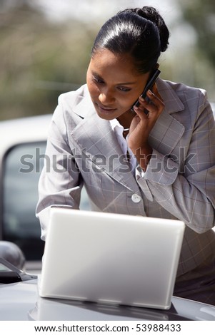 Portrait of a young businesswoman with a laptop computer and a phone