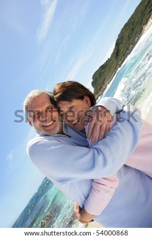 Portrait of a happy senior couple embracing on the beach