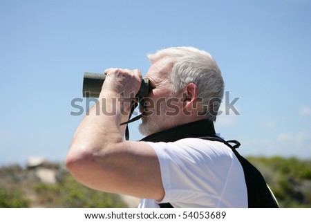 Portrait of a senior man looking through binoculars