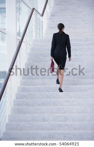 Young woman with a suitcase climbing stairs