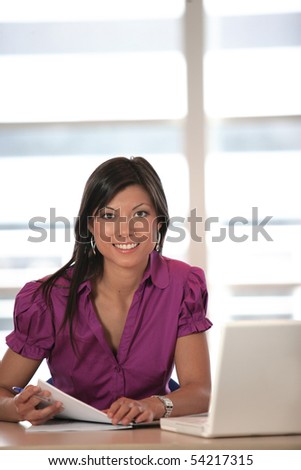 Portrait of a smiling woman in front of a laptop computer