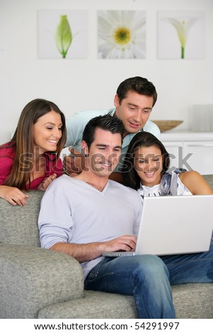 Men and women smiling in front of a laptop computer