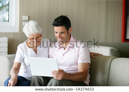 Portrait of a senior woman and a man in front of a laptop computer