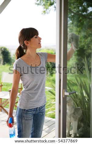 Woman cleaning the outside windows of a house